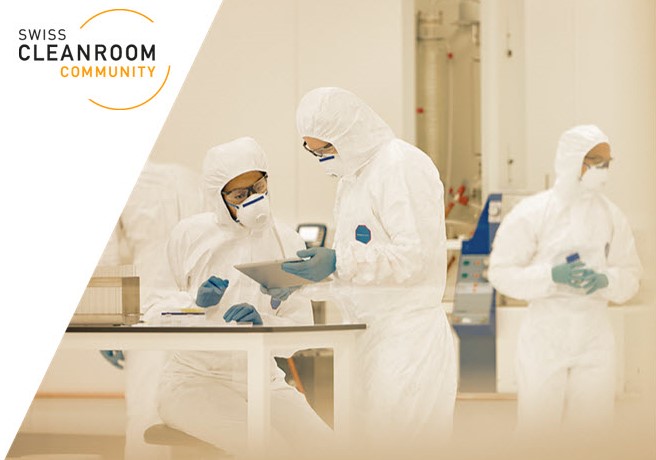 Scientists wearing cleanroom suits working together in a sterile laboratory environment.